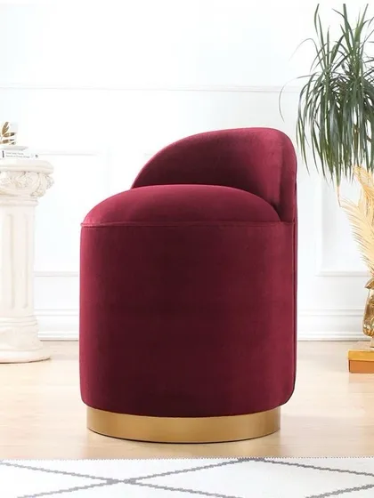 How cute is this ottoman? This piece features a cylindrical form upholstered in rich burgundy velvet, with a polished gold swivel base, adding a touch of glamour and versatility.