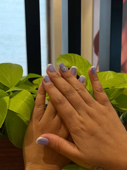 A lovely two-hand pose showing the full lavender and daisy nail art set. It’s a sweet and chic look for any season.