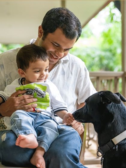 A father, his son, and their loyal dog. Anand shares a beautiful moment with his son Vyom, while Rio the dog looks on with gentle curiosity. This is a perfect example of a candid family portrait where the pet is an integral part of the scene.