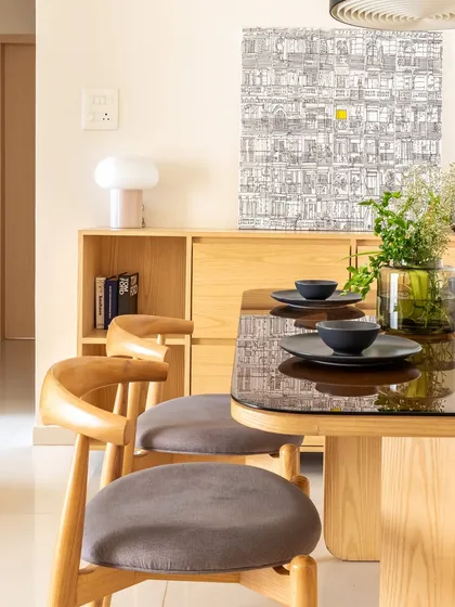 The dining area embraces the Wabi-Sabi philosophy of finding beauty in raw, imperfect materials. The wooden table and chairs are simple, elegant, and timeless.