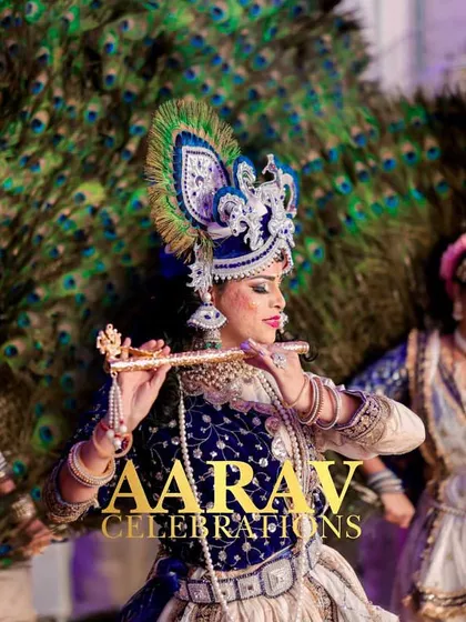 An artist portraying Krishna plays the flute, surrounded by Gopis against a backdrop of peacock feathers. This level of thematic detail creates a truly divine and memorable performance.