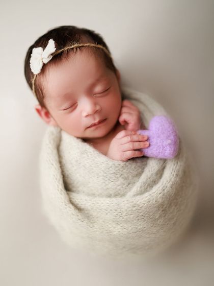 Sweet baby Veda, cocooned in shades of grey and lavender. Even a simple wrap and a tiny prop like this felt heart can create a beautiful, memorable portrait.