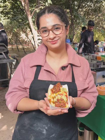 Me holding a serving of our loaded fries at a food market. I love these events because they give me a chance to interact with customers and get their feedback in person.