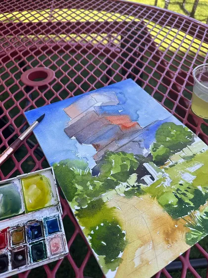 A work-in-progress shot of my painting of the BU Data Science building, showing my watercolour palette and the initial layers of colour.
