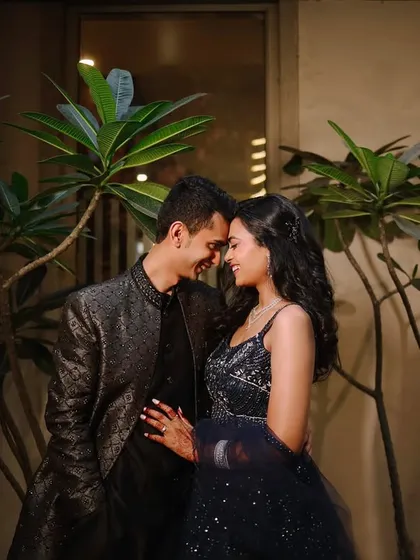 A candid, happy moment between the couple, framed by lush greenery at night. Their genuine smiles and relaxed posture show that even posed shots can feel natural and full of love.