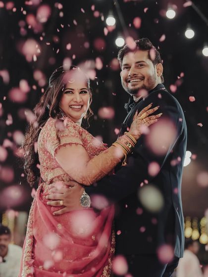 Our beautiful bride Bhumi, twirling in her stunning pink lehenga at her reception. The backdrop of fairy lights and floral decor created a magical setting for her to shine.