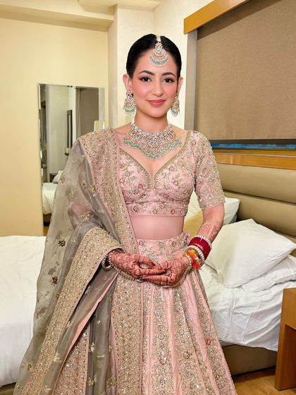 The picture of innocence. This bride's pastel pink lehenga was paired with fresh, dewy makeup and a pop of pink on the lips.
