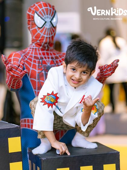 Striking a pose with Spider-Man. We designed this personalized white blazer to be the highlight of his Avengers-themed birthday, ensuring he felt like a real superhero.