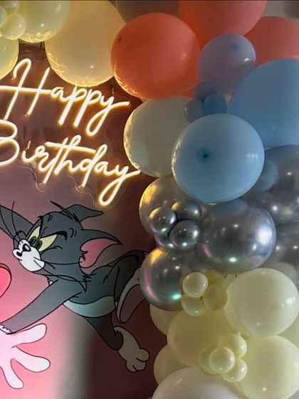 Another backdrop option for the Tom and Jerry theme, featuring a 'Happy Birthday' neon sign and a colorful balloon arrangement.