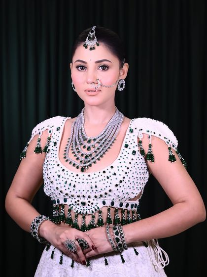 This full-length view shows how the makeup, hair, and outfit come together. The clean, elegant makeup balances the heavily embellished white and green lehenga, creating a sophisticated and modern bridal style.