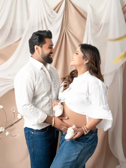 A sweet and casual maternity photo where the couple holds tiny baby shoes up to the baby bump. This simple, heartfelt pose is perfect for capturing the excitement of expecting.