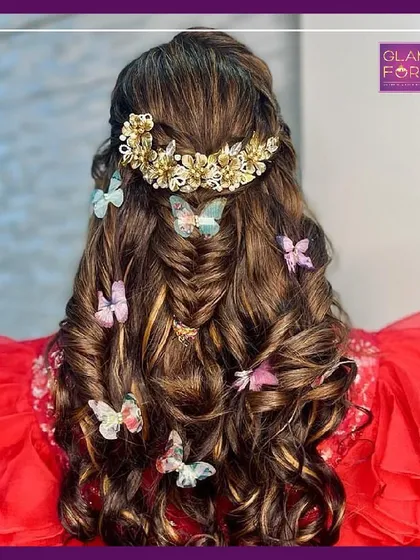 A whimsical and romantic hairstyle with a fishtail braid and butterfly accessories. This look shows the creative side of hairstyling that we encourage in our classes.