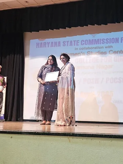Receiving a certificate on stage at D.A.V. College for Girls, Yamuna Nagar, after speaking at an awareness program on Legal, POSH, and POCSO issues.