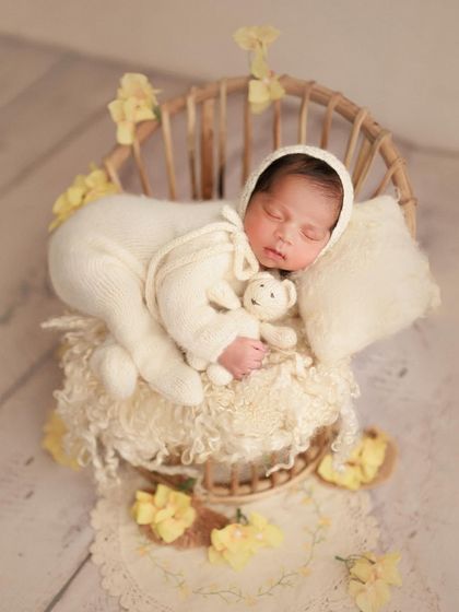 A cozy Diwali greeting. This little one is sleeping peacefully in a basket, surrounded by yellow flowers, celebrating the festival of lights.