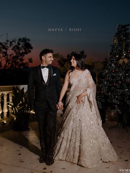 Navya and Rishi walking hand-in-hand at dusk, a beautiful and romantic scene from their engagement.