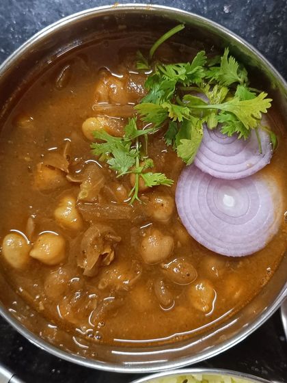 A close-up of my homestyle chole, garnished with fresh coriander and onion rings. It's a classic North Indian dish that is both comforting and full of flavor.
