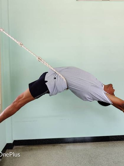 Viparita Dandasana (Inverted Staff Pose) in the ropes. This is an advanced backbend that creates a deep arch in the entire spine. The ropes provide the necessary support to hold the pose safely.
