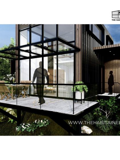 A render of a container home with a large deck, showing a person walking towards the entrance.