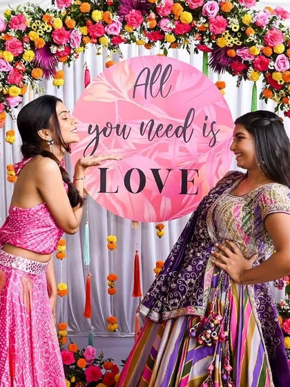 "All you need is LOVE." A fun and colorful circular photo arch, perfect for capturing playful moments during a mehendi function.