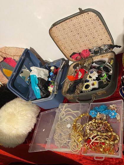 Suitcases and boxes filled with jewelry, sunglasses, and other accessories for the dress-up session.