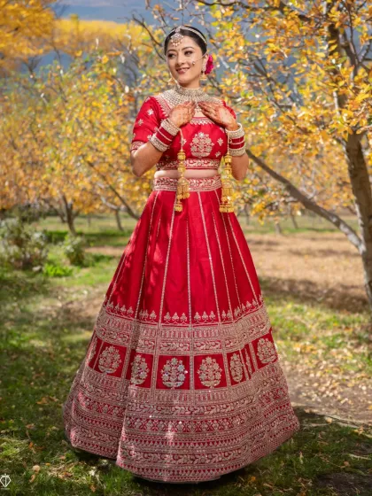 A full-length bridal portrait in an apple orchard in Kinnaur. Using the natural landscape helps create unique and memorable wedding photographs.