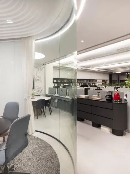 A view from a glass-walled meeting room into the open-plan office. This image shows how we use transparency to create a connected and open work culture.