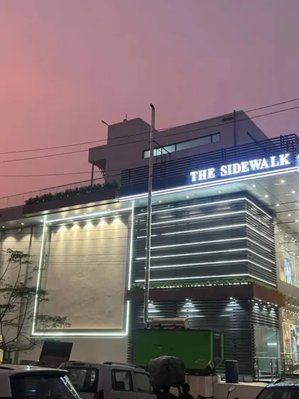 An evening shot of 'The Sidewalk' commercial building, showcasing the full extent of the facade lighting I designed. The illuminated frame on the left is designed for large-format advertising, adding to its commercial viability.