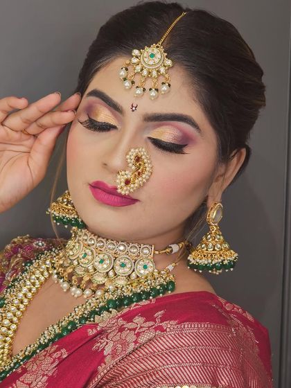 A detailed shot of the eye makeup, featuring a beautiful blend of gold and pink with a sharp liner. The traditional nath adds the perfect finishing touch.