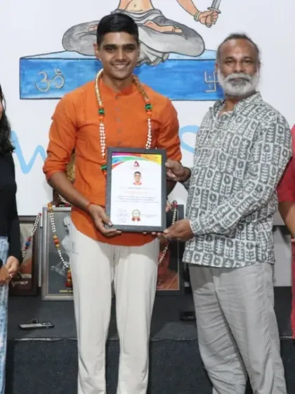 A student proudly receives his Aerial Yoga TTC certificate. Our specialized courses empower students to teach unique and popular styles of yoga.