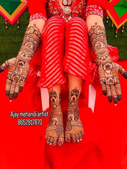 A stunning display of full bridal mehndi on a vibrant red background. The designs on the hands and feet are perfectly matched and full of detail.