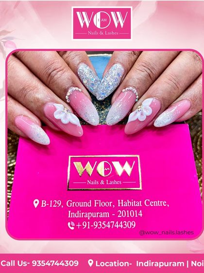 A stunning bridal or party look. These long, stiletto nails feature a pink and white ombré with a heavy application of silver glitter and delicate 3D floral accents.