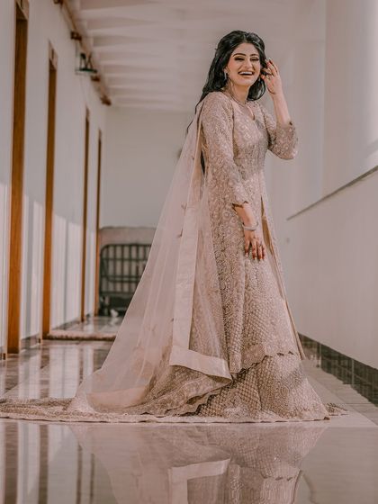 A happy, laughing portrait of a bride in a beautiful gown, captured in a bright, airy corridor.