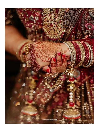 A close-up of Reshma's hands, adorned with intricate henna and traditional kalire. These details are an essential part of the North Indian bridal story.