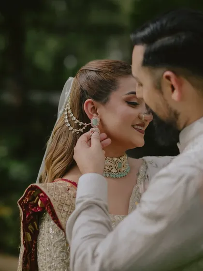 A tender gesture speaks volumes. The groom gently adjusting the bride's earring is a small, intimate moment that we love to capture, showing care and affection.