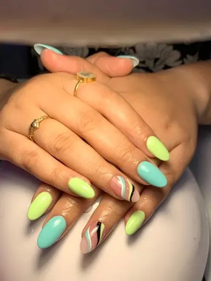 A fun pastel set with a mix of light green and blue nails and abstract, colorful accent nails.