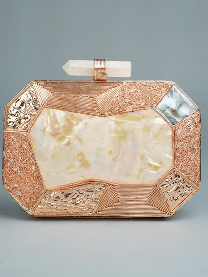 This rose gold brass clutch has a modern, geometric design. The central mother of pearl inlay is framed by textured and engraved metalwork, and the quartz crystal clasp adds a final touch of luxury.