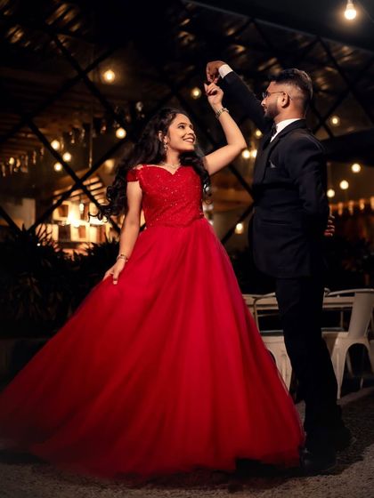 A dance to celebrate their love. This couple's engagement photo is full of joy, with the bride twirling in her red ball gown.
