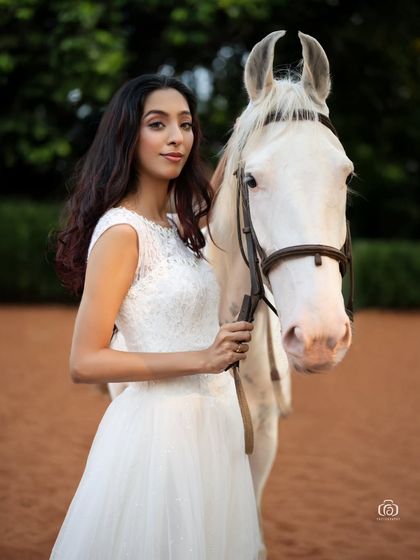 A beautiful portrait from the equestrian beach shoot, taken on the sand. The warm tones of the sand and the soft lighting create a romantic and classic fashion image.