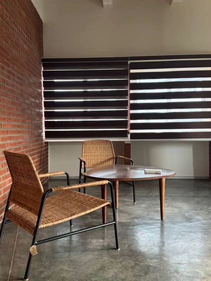 A quiet seating nook in an interior project for Samagataorg on Church Street, Bangalore. The combination of an exposed brick wall, polished concrete floor, and modern wicker chairs creates a contemporary yet warm aesthetic.