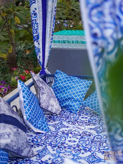 A cozy seating nook inside one of the canopies, with cushions in coordinating blue and white patterns.