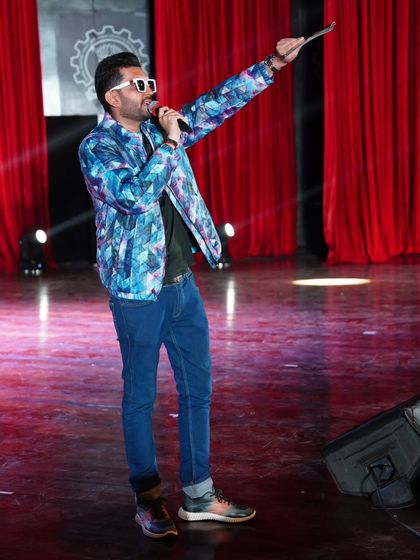 Pointing towards the next big moment. As a host, I guide the audience's attention and build anticipation for what's to come.