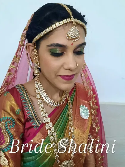 Here is a close-up of the bride's Varapooja makeup, with a sheer veil. The focus is on the bold green and gold eyeshadow and a deep berry lip, a classic combination for South Indian pre-wedding ceremonies.