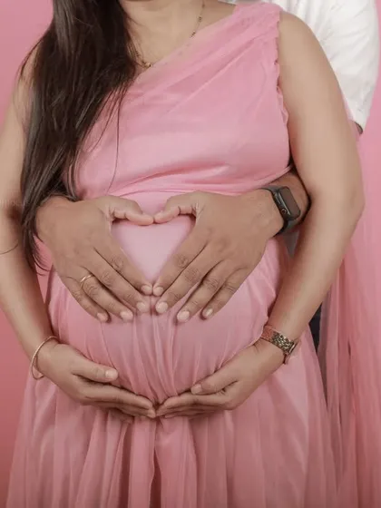 A classic heart-hands pose on the baby bump, a simple yet powerful image we can capture in any studio session.