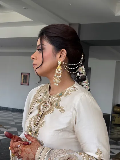 An identical shot to 16, showing the beautiful side profile of the client with her intricate parandi braid and matching earrings.