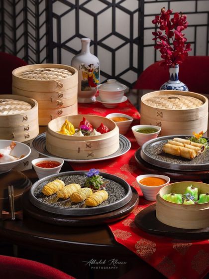 An elaborate table setting filled with various dim sum steamers and plates for the Shang Palace menu.