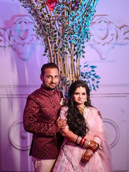 A lovely portrait of the couple at their reception. They look happy and relaxed, posing together in front of the elegant decor, a perfect memory of their special evening.