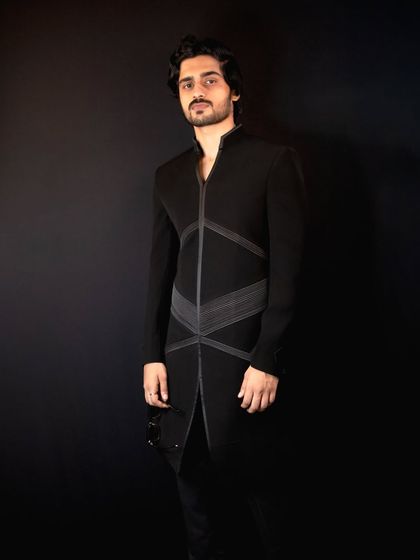 This full-length shot shows the sleek and modern silhouette of the 'Grooved Lines' Indo-Western outfit, designed for a confident and stylish presence.