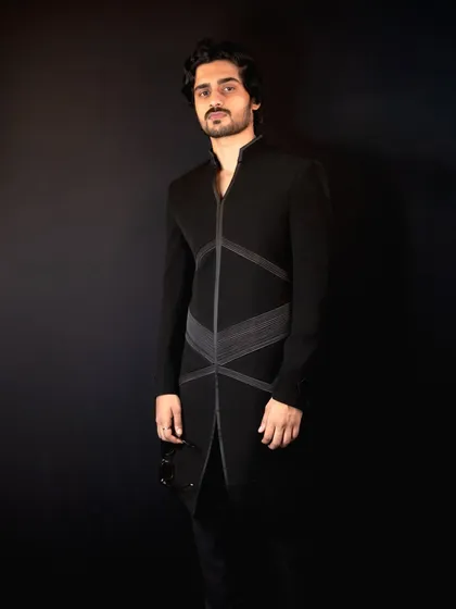 This full-length shot shows the sleek and modern silhouette of the 'Grooved Lines' Indo-Western outfit, designed for a confident and stylish presence.