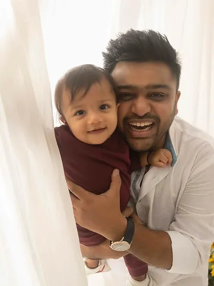 Peek-a-boo! A fun and candid shot of a father and son playing behind a curtain, full of laughter and joy.