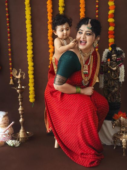 A playful and candid moment between a mother and her baby on her back, both sharing a laugh.